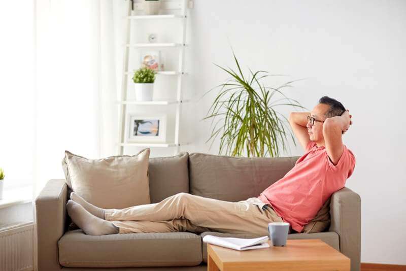 man-in-glasses-relaxing-on-sofa-at-home