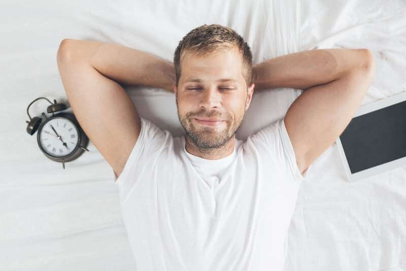man-sleeping-on-bed-after-using-his-digital