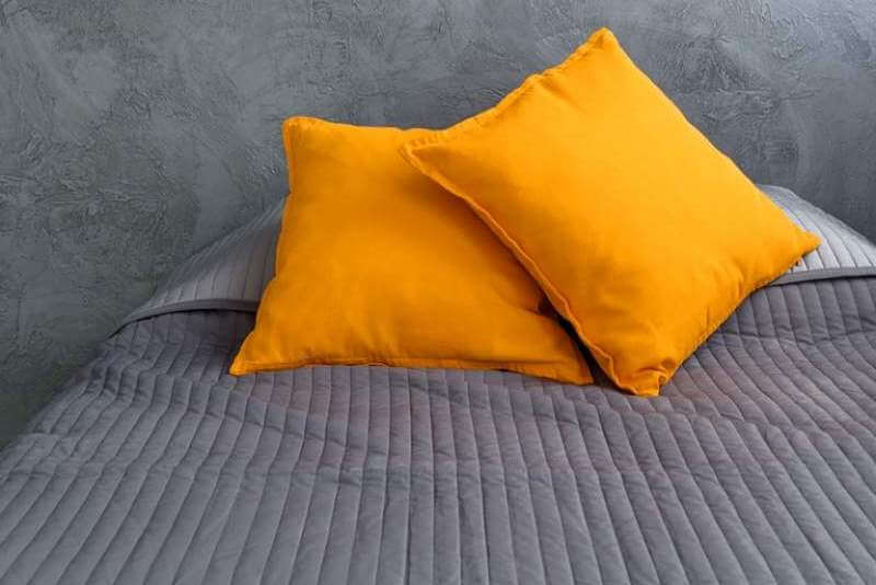 grey-bed-and-orange-pillows